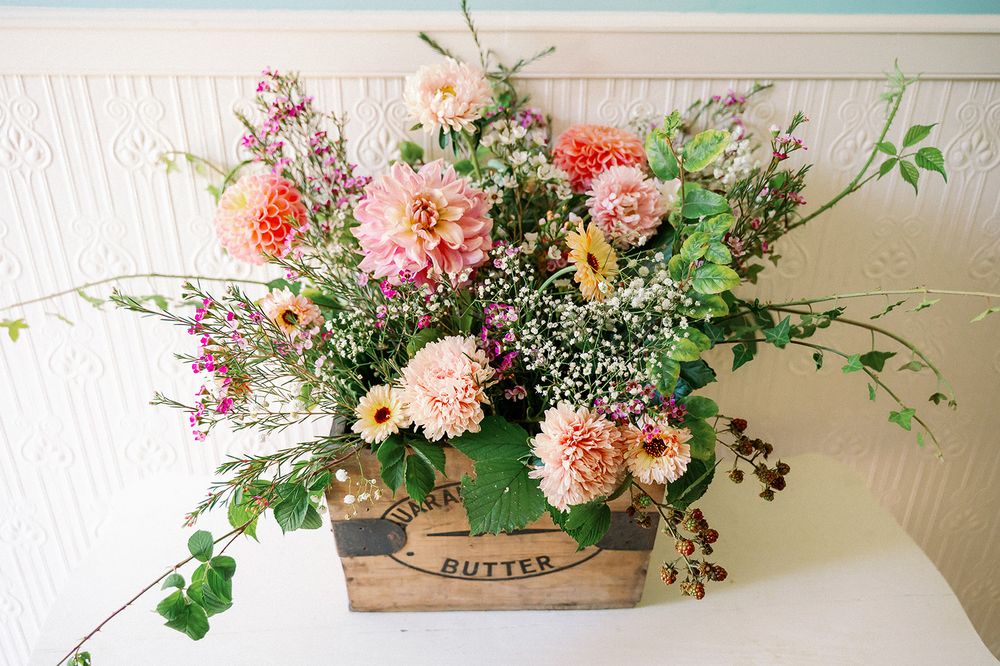 Elegant floral arrangements with pink and peach blooms in rustic wooden boxes.