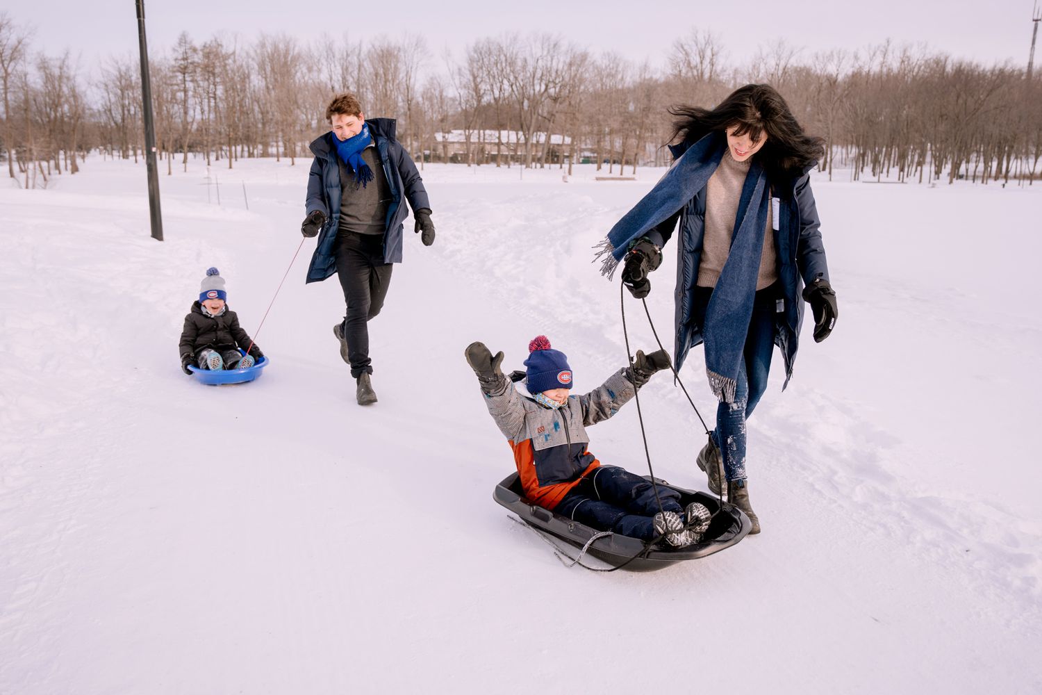 Seance photo de famille dans la neige en hiver au parc du Mont-Royal à Montreal.