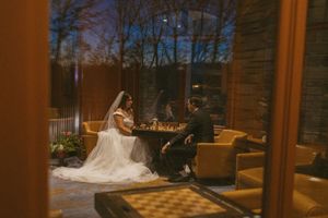 A bride in a white gown spins on a dance floor surrounded by yellow seating and wooden decor.