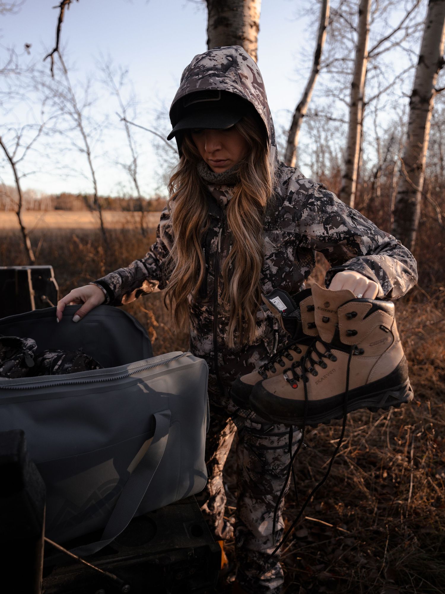 Outdoor equipment being handled in wooded setting during golden hour.