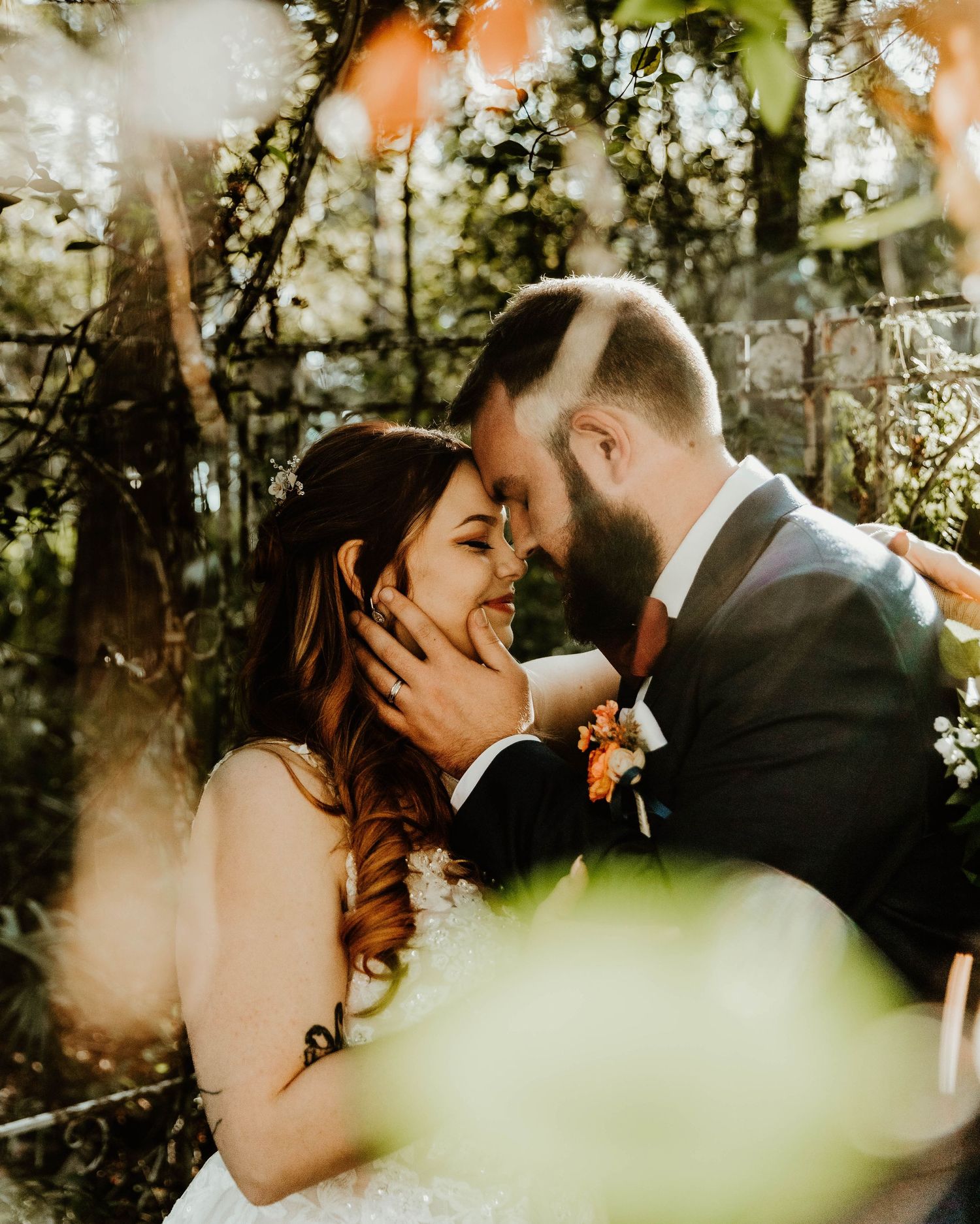 Romantic couple shares intimate moment among blooming spring flowers and natural light.