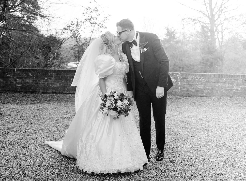 A romantic black and white wedding photo series showing tender moments between newlyweds in an outdoor garden setting.