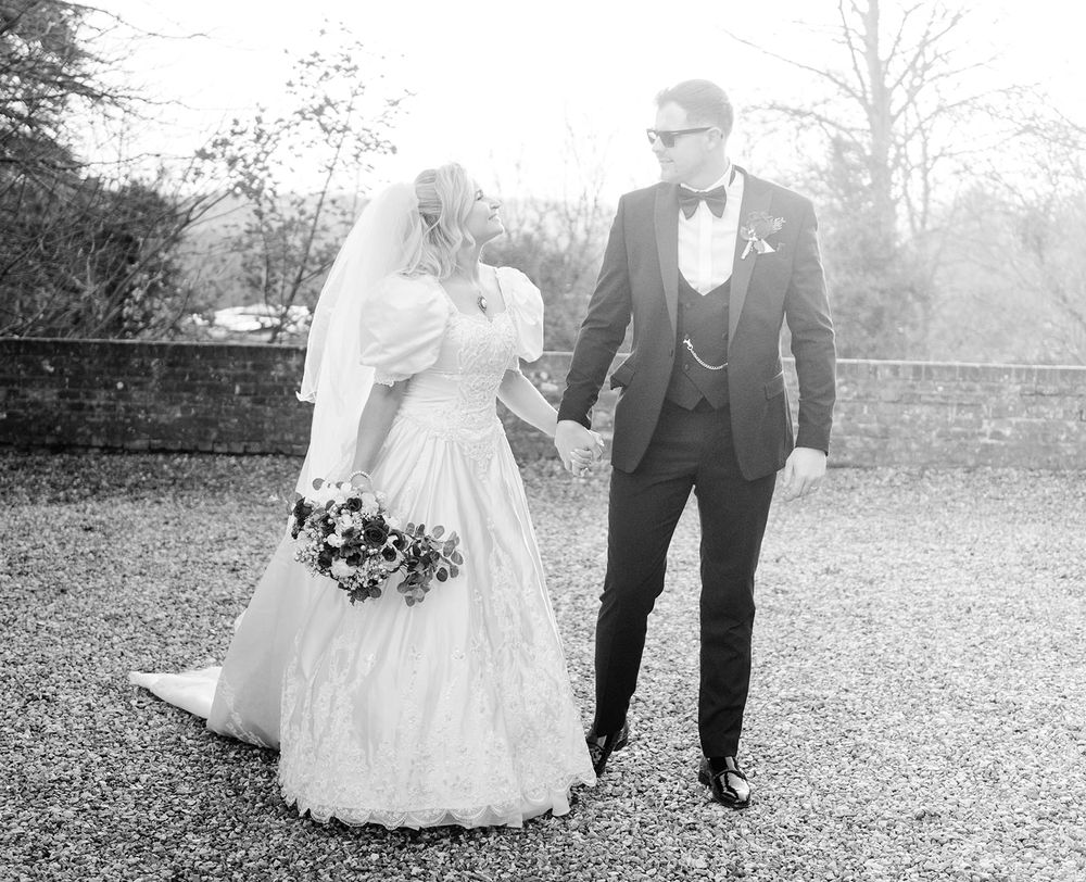 A black and white photo sequence shows a couple walking together in formal attire through an outdoor garden setting.