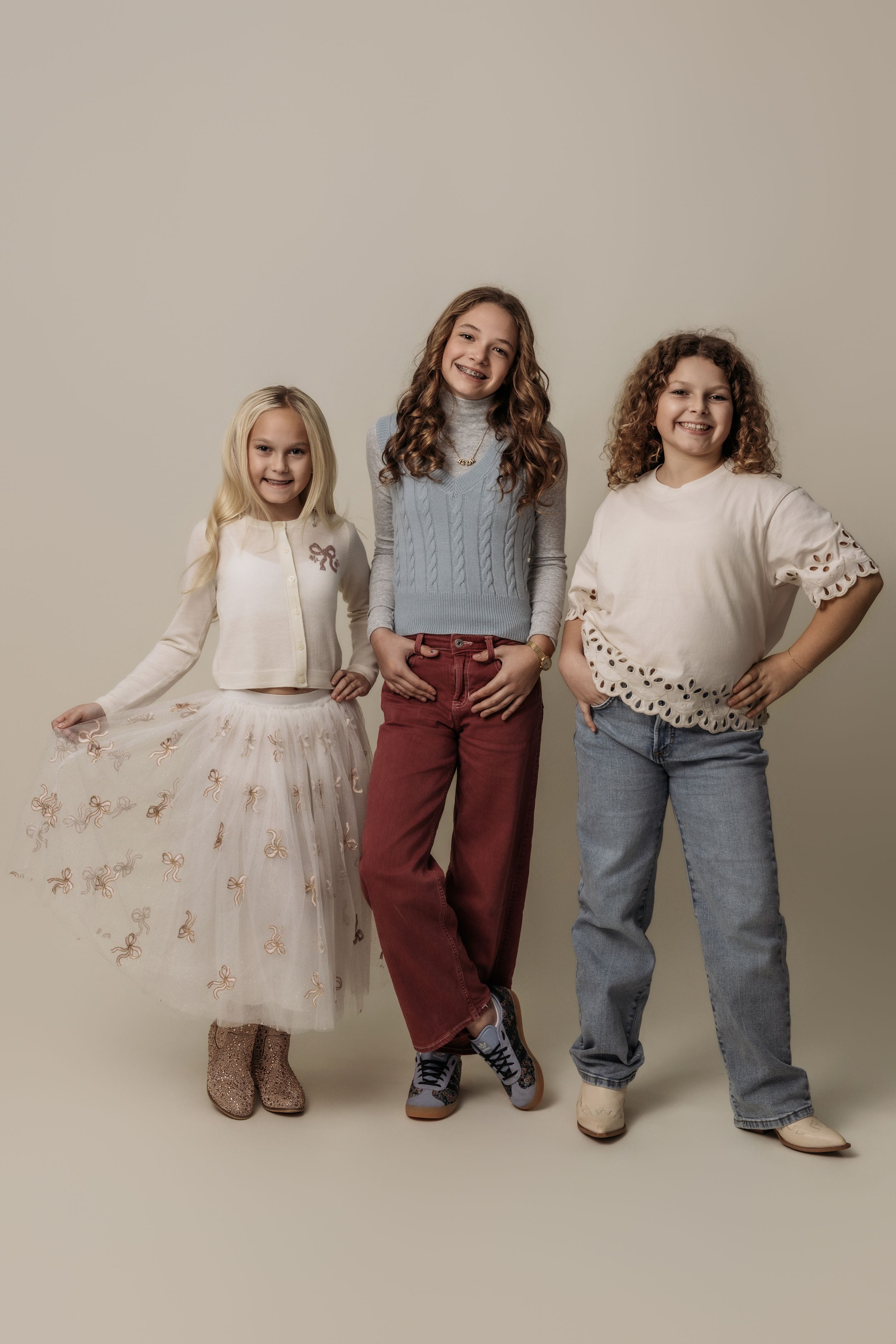 Group portrait of children wearing coordinated white, burgundy and blue casual outfits.