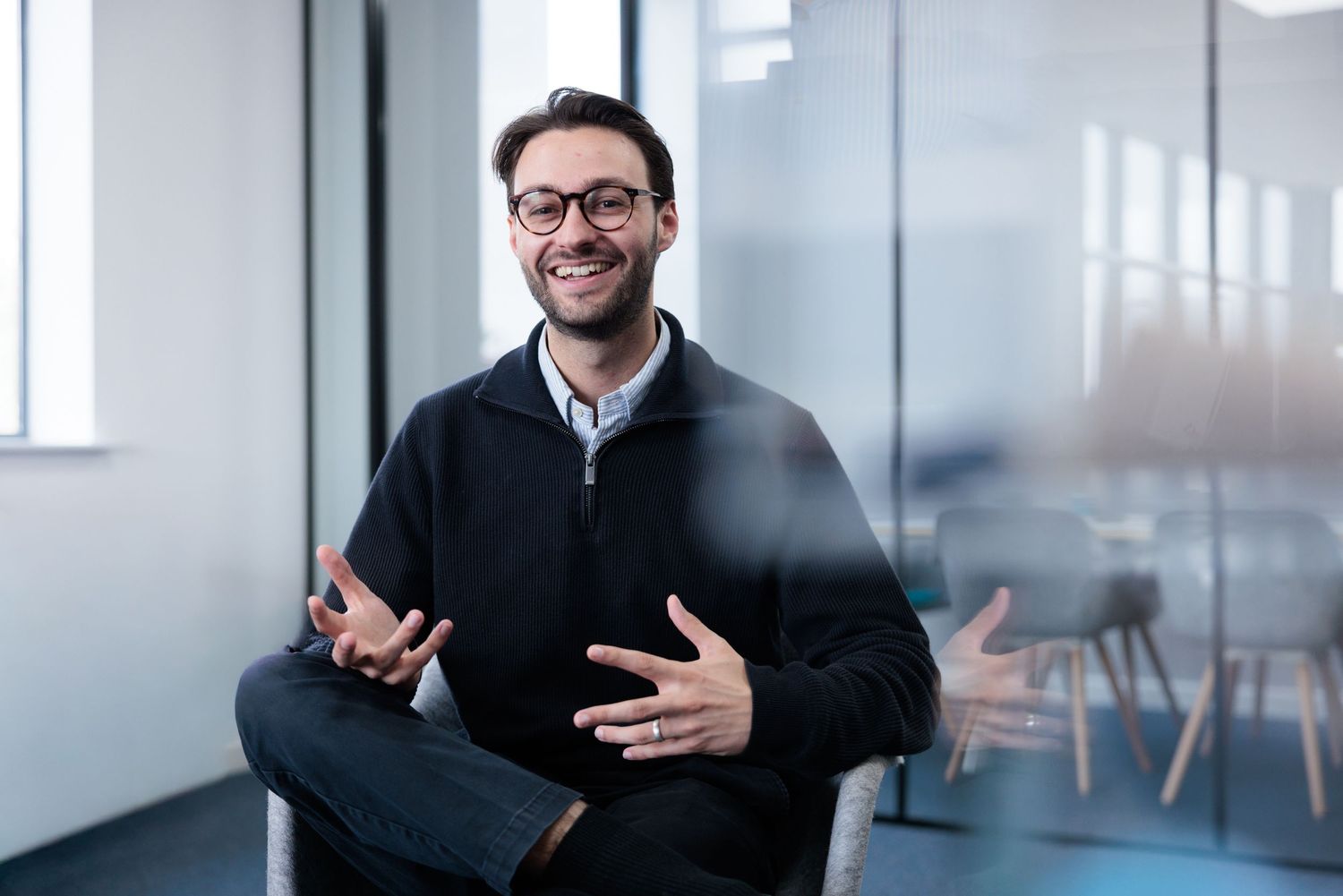 Professional in business attire gesturing during conversation in modern office space. Headshots. Corporate Portraits