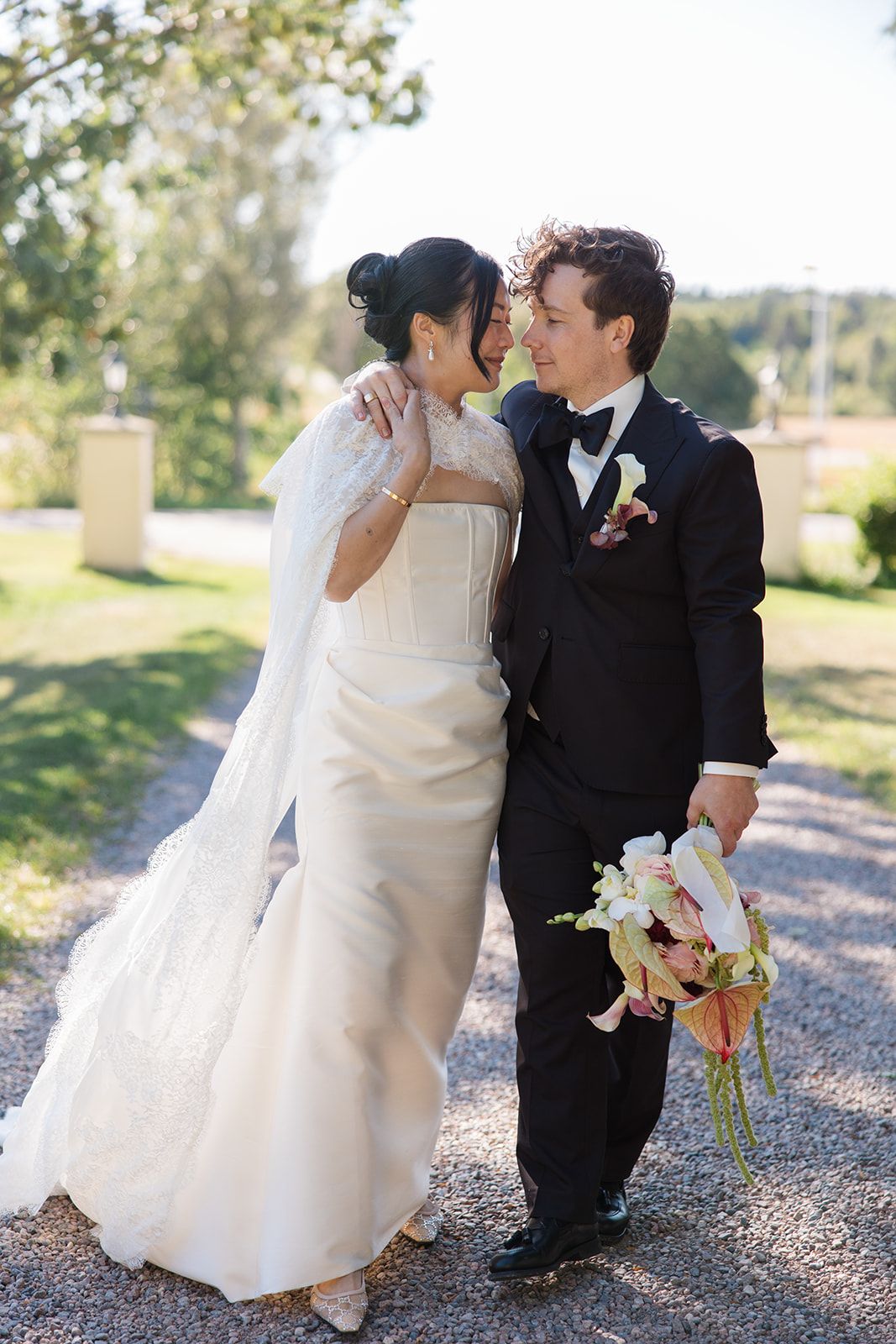 A bride and groom share romantic kisses in a series of outdoor wedding photos on a gravel path.