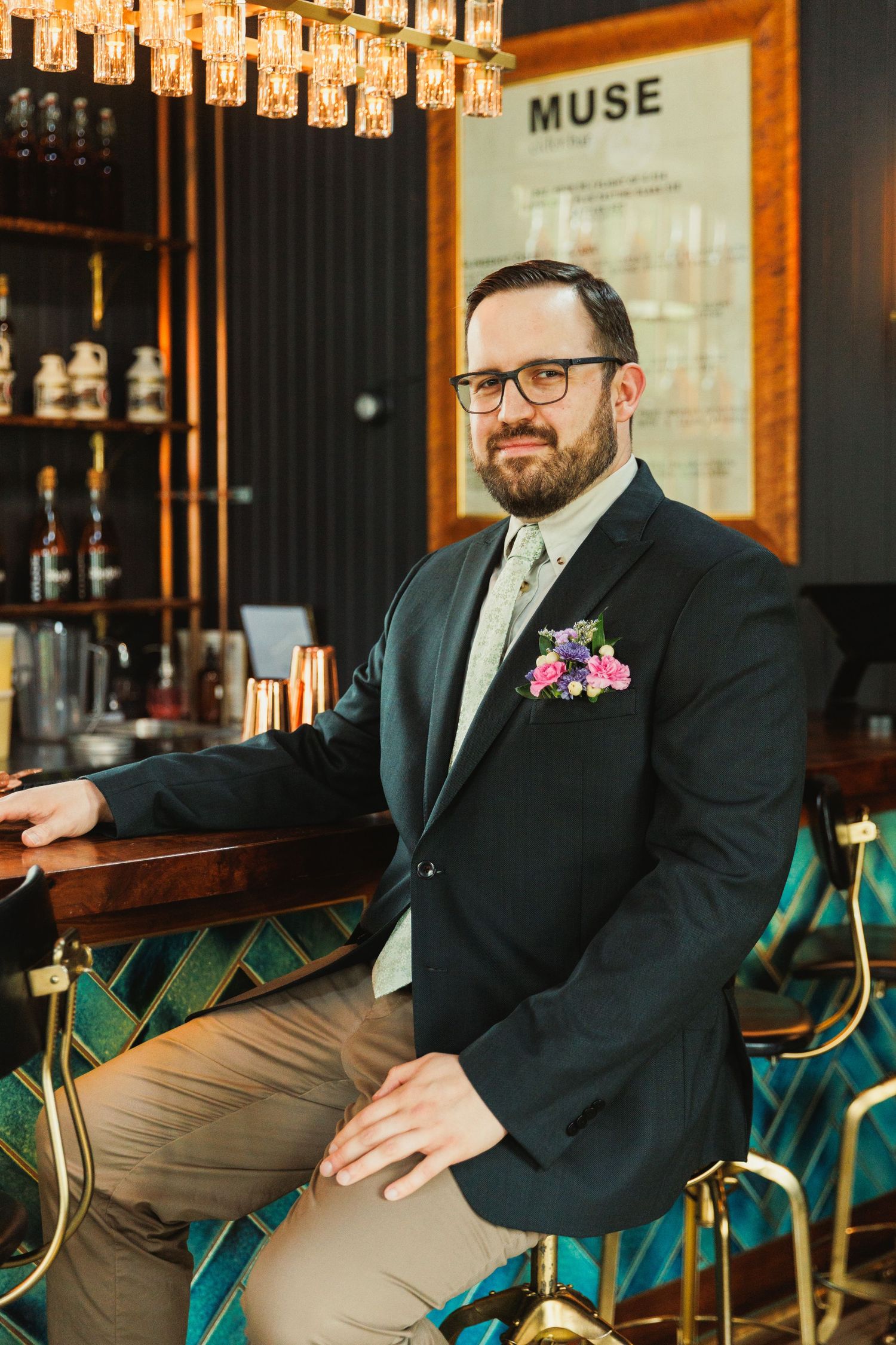Stylish bar setting with green chairs and warm lighting at venue called Muse.