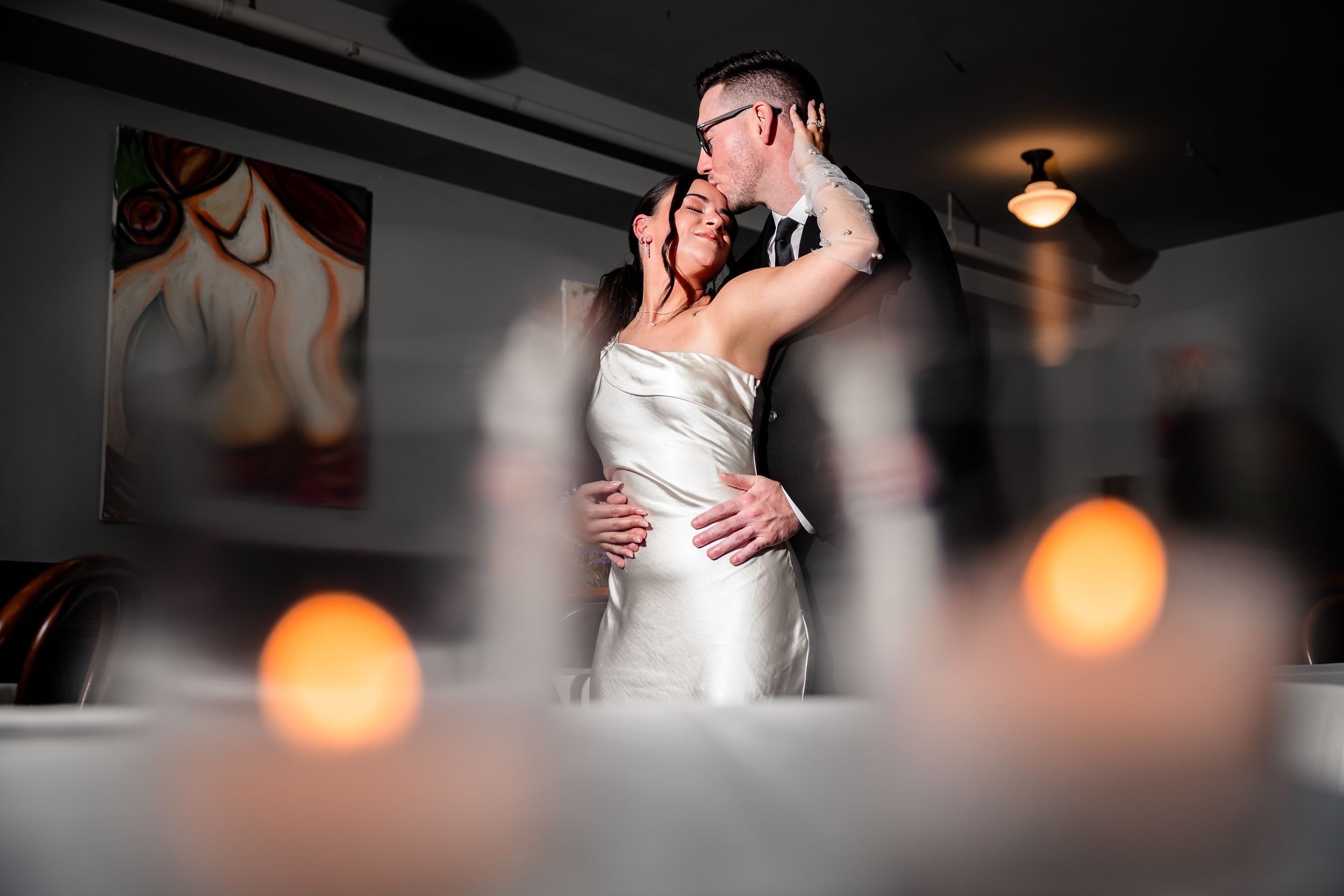 A series of romantic dance moments captured in low light with bokeh effects at an indoor venue.