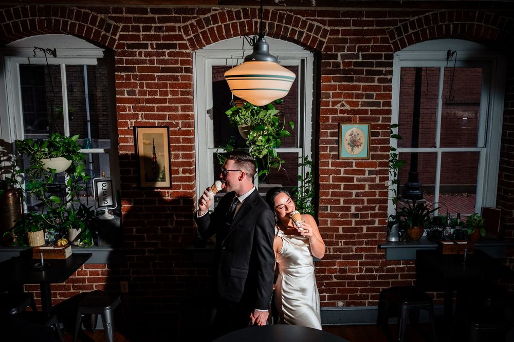 A romantic scene unfolds against a rustic brick wall backdrop with moody lighting and warm glowing orbs.
