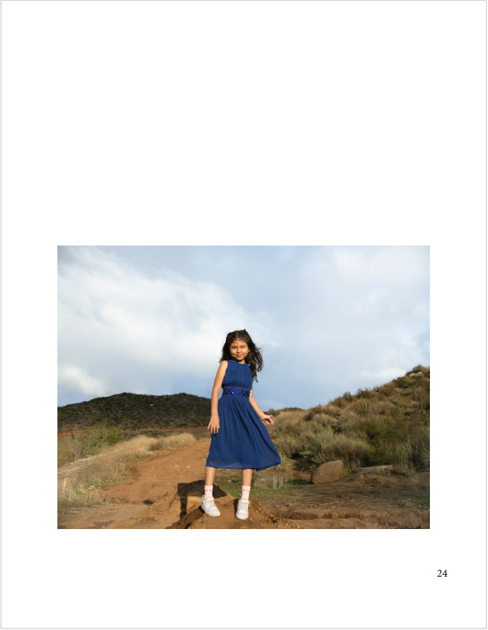 girl wearing a blue dress and sneakers near hills
