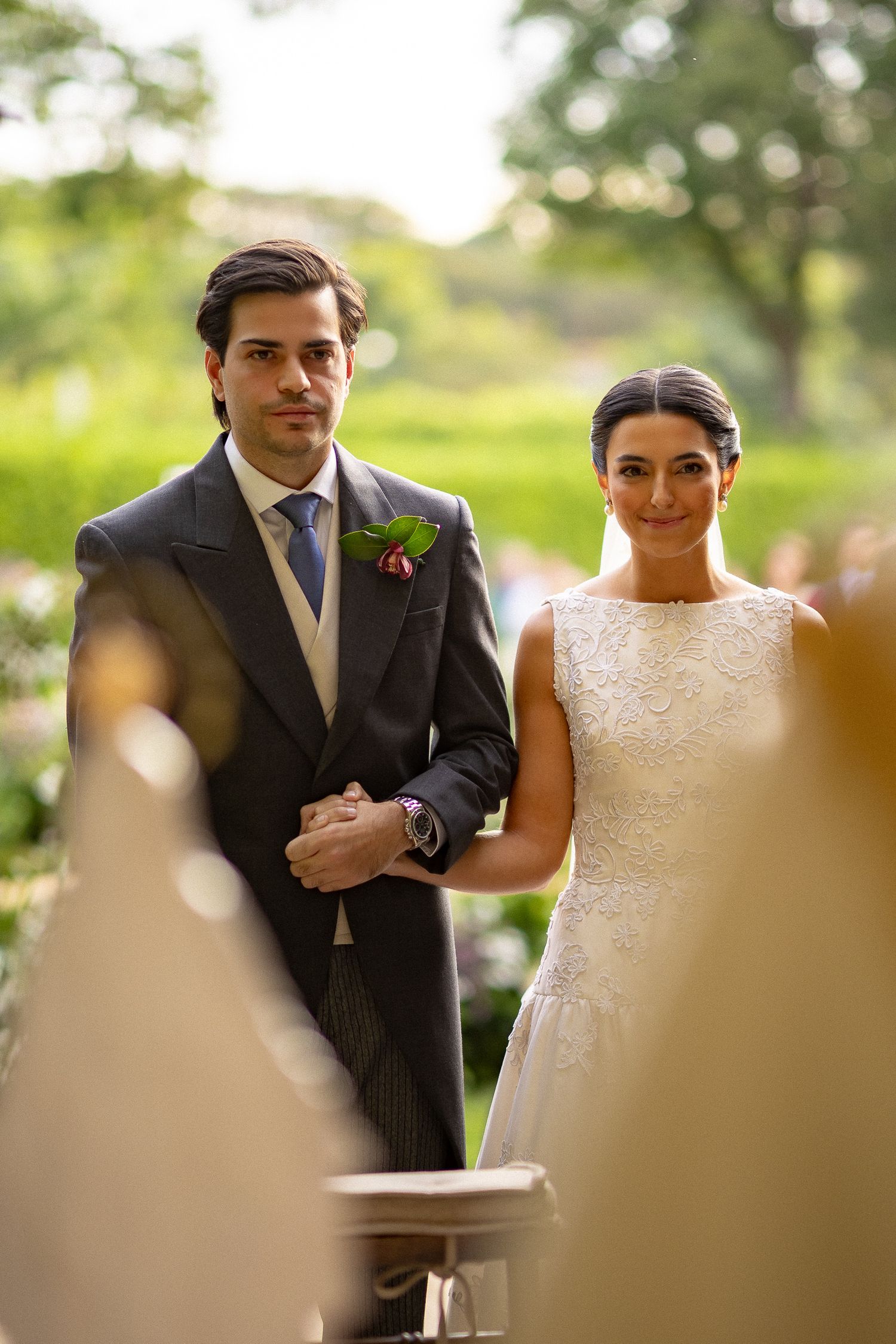 Newlyweds share an intimate moment during their outdoor wedding photoshoot in a lush garden setting.