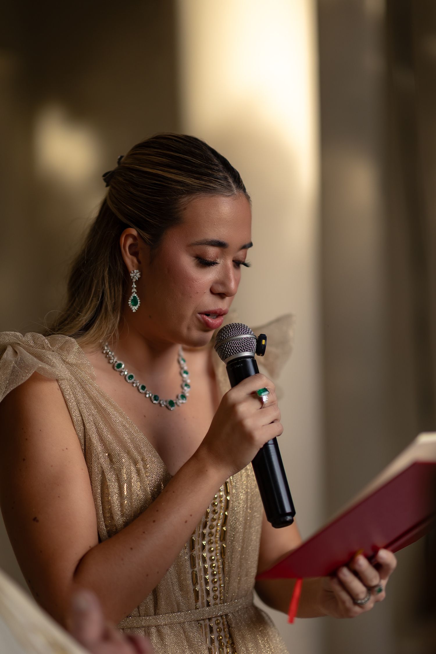 A singer in a gold dress and blue jewelry performs emotionally with a microphone in a series of sequential photos.