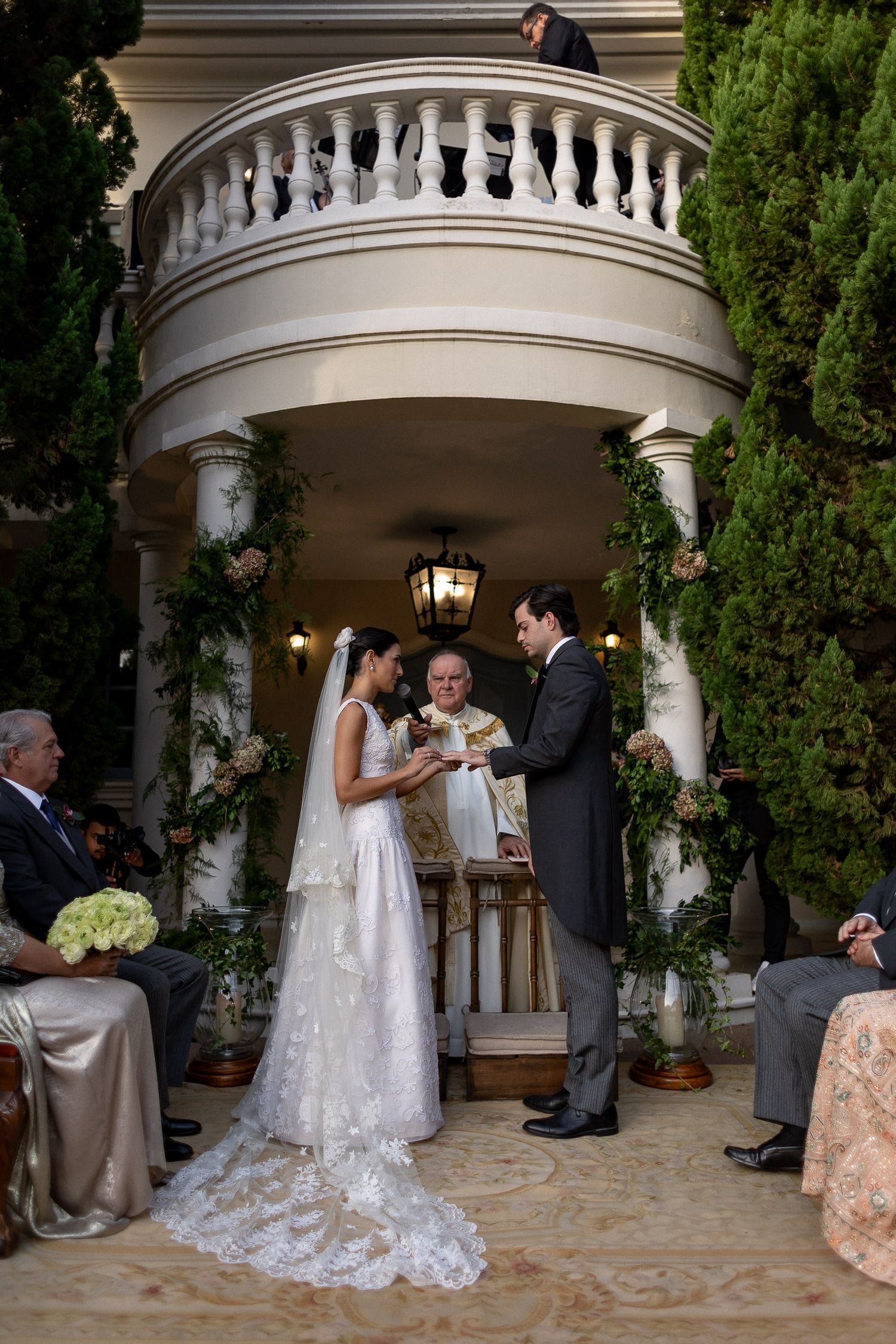 Wedding ceremony sequence showing vows being exchanged under an ornate white gazebo with decorative railings.