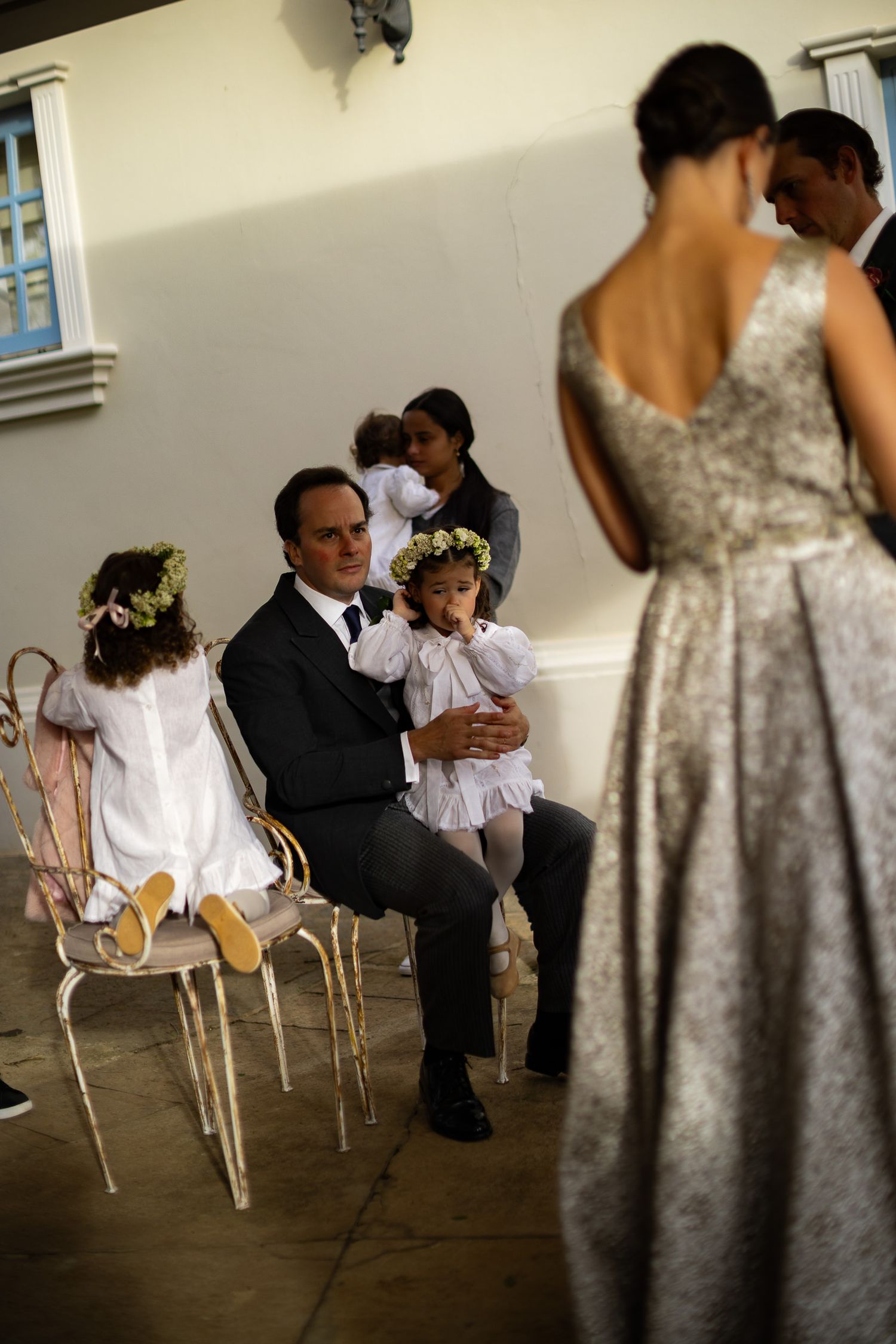 Wedding party members play musical chairs during reception celebration with gold chairs.