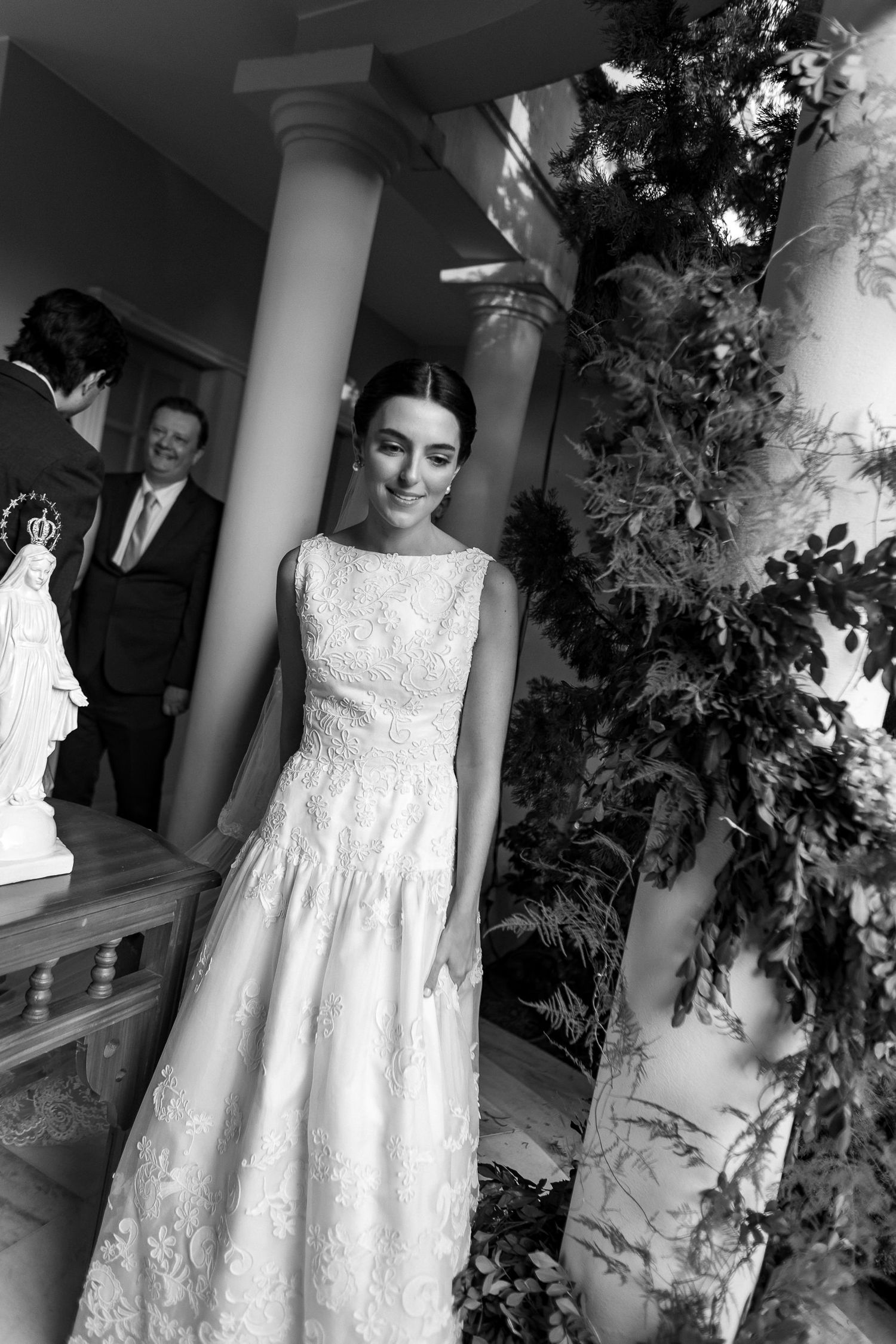 A series of black and white photos showing a young girl in an elegant white lace dress posing in different positions.