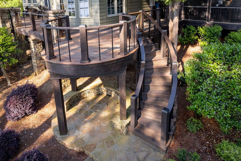 A decorative wrought iron fence with ornate details casts shadows on a concrete pathway in an urban setting.
