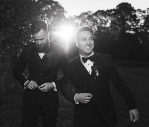 A series of black and white wedding photos showing candid moments between a couple outdoors at sunset.