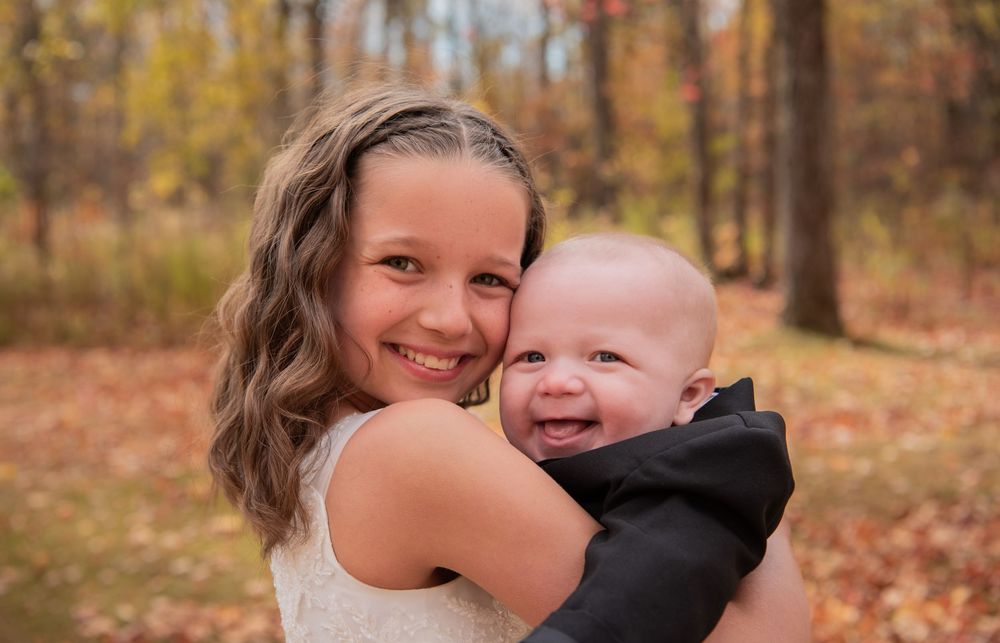 A series of candid autumn family photos showing tender moments between loved ones in a forest setting.