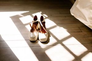 Photo de préparatifs paire de chaussures de la mariée mise en valeur par l'ombre de la fenêtre