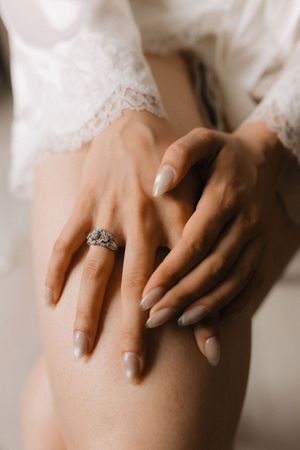 Photo de détail préparatifs de mariage mettant en valeur la bague de fiançailles de la mariée