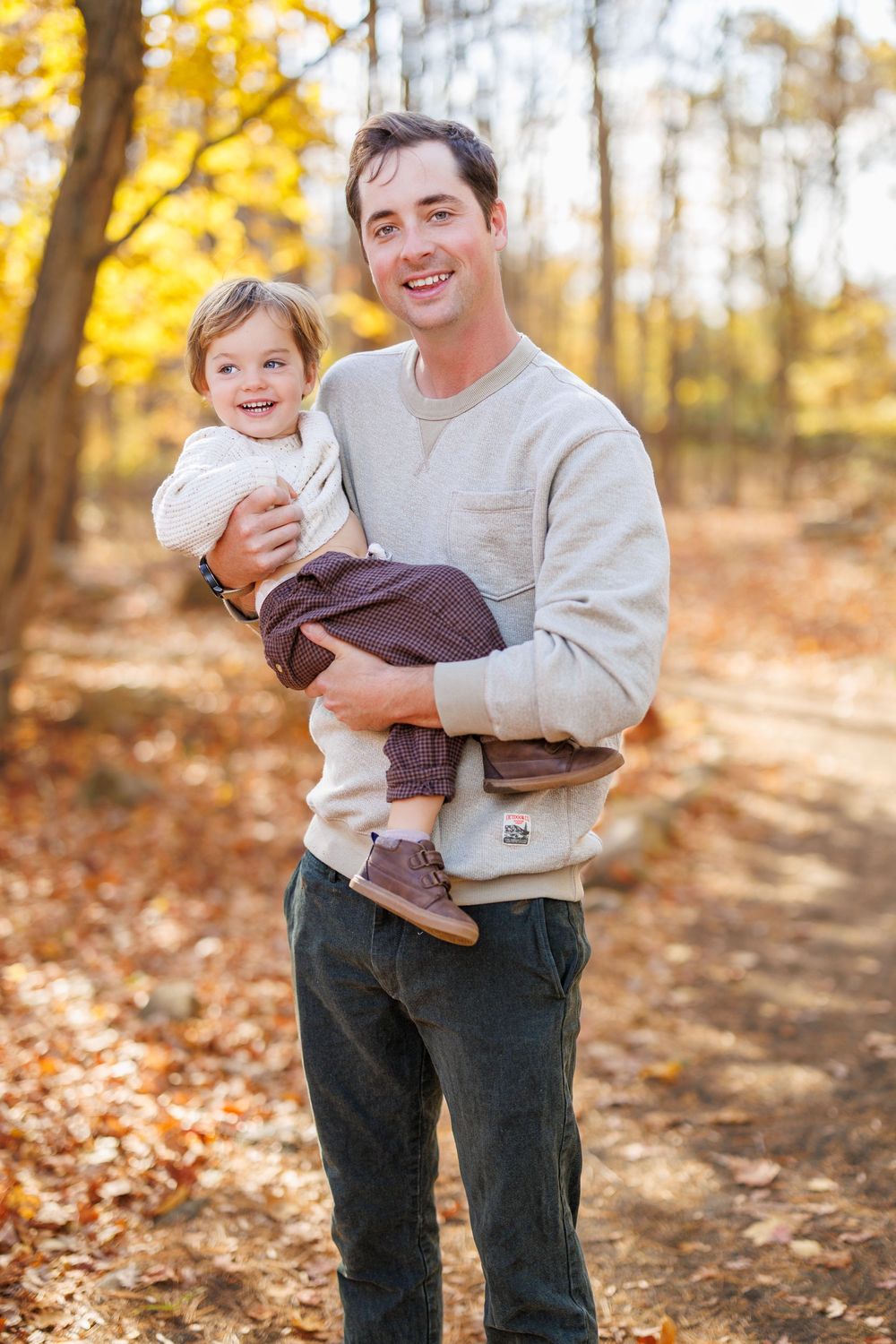Casual outdoor portrait in a sun-dappled autumn forest setting.