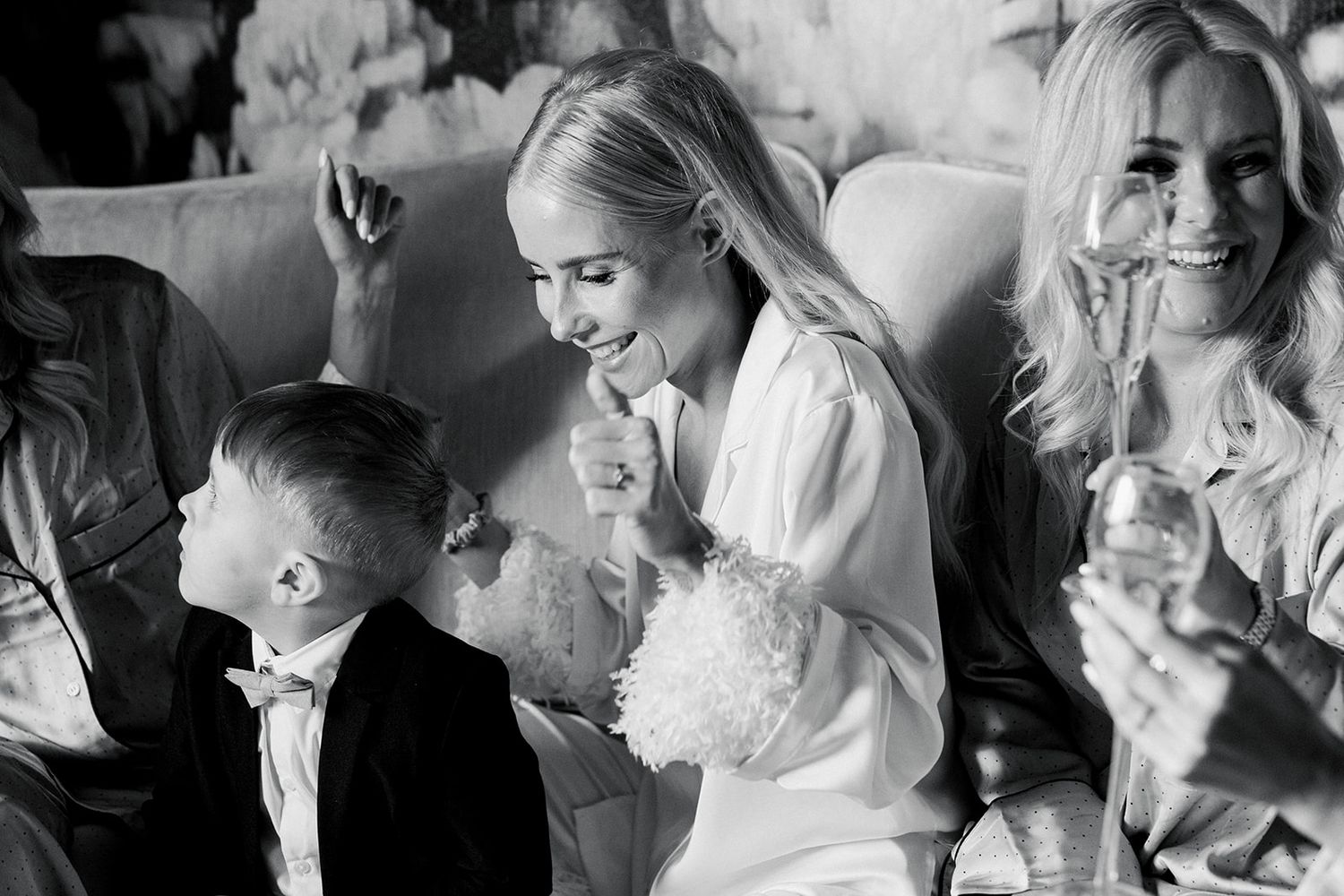 Candid black and white wedding moments showing emotional reactions and embraces during a celebration.