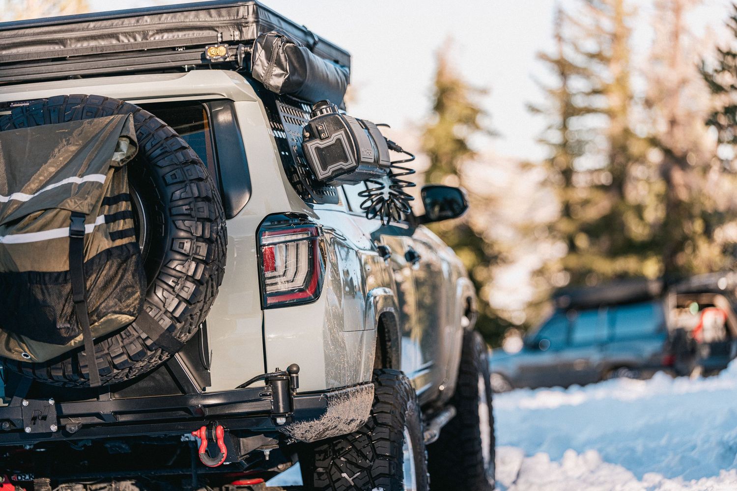 A close-up sequence showing a vehicle's rear bumper and tow hitch being attached in snowy winter conditions.