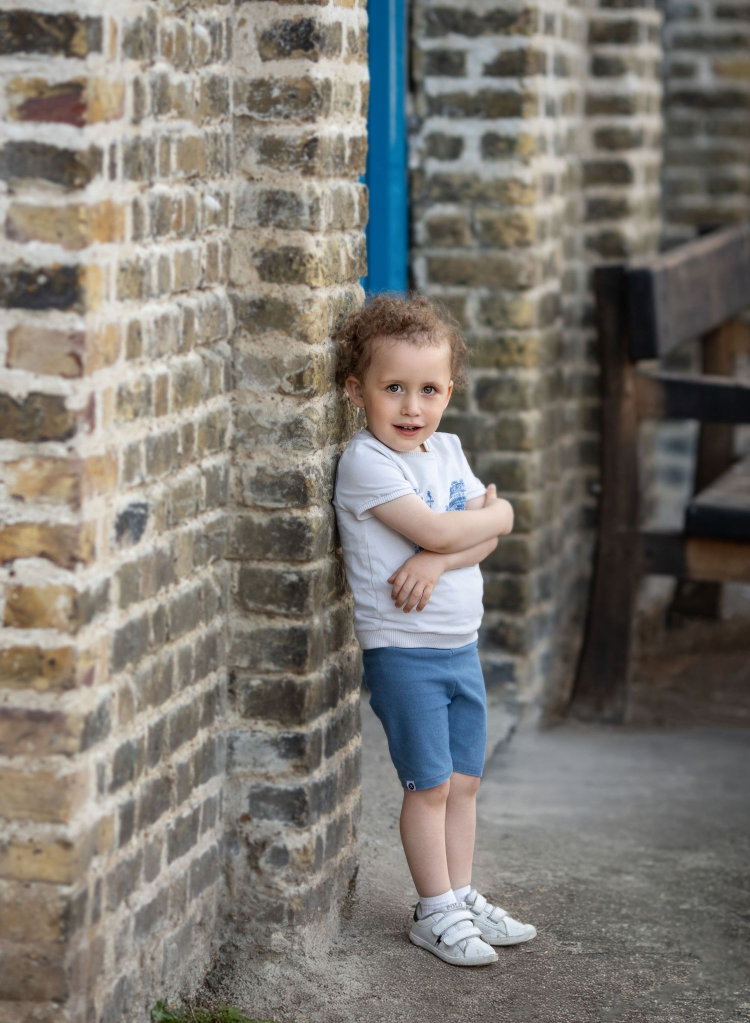 A portrait of a boy folding his arms.