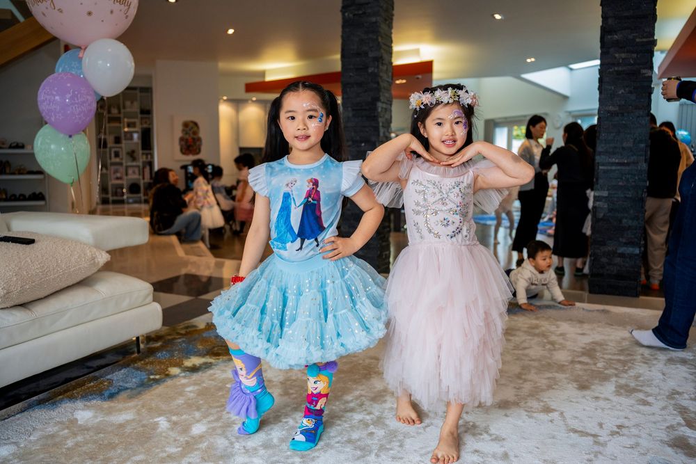 Two happy girls in beautiful princess dresses celebrating at a kids birthday party on the North Shore, Auckland.