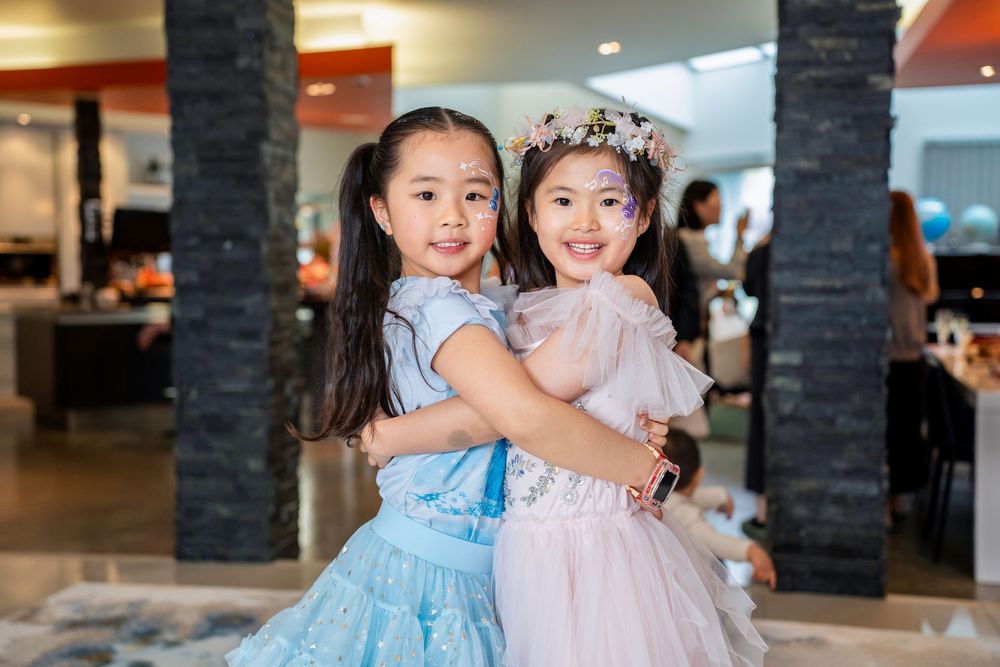 Two happy girls in beautiful princess dresses celebrating at a kids birthday party on the North Shore, Auckland.