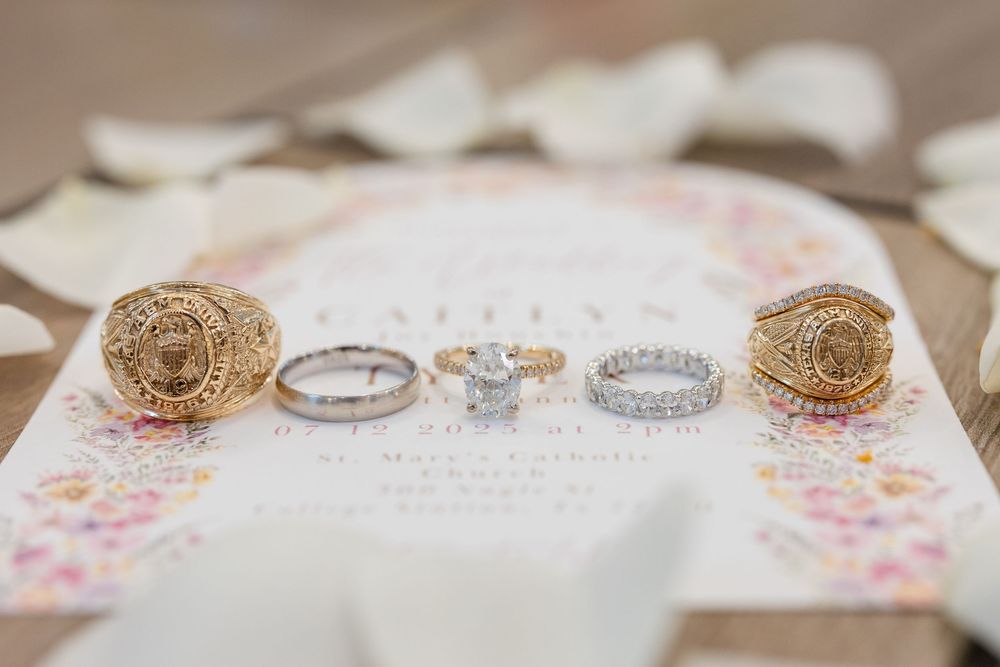 Wedding rings and decorative details arranged on floral stationery.