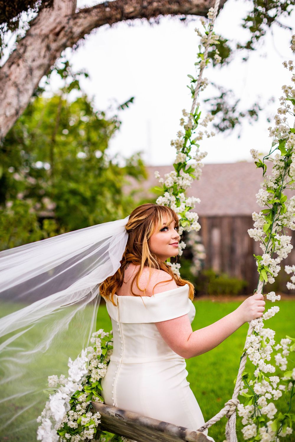 Dreamy bridal portrait with flowing veil and white spring blossoms.