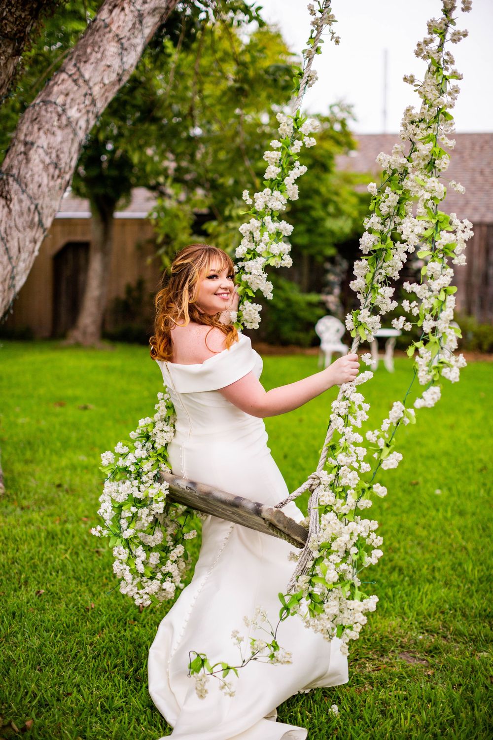 Joyful bridal moment captured with flowering branches in garden setting.