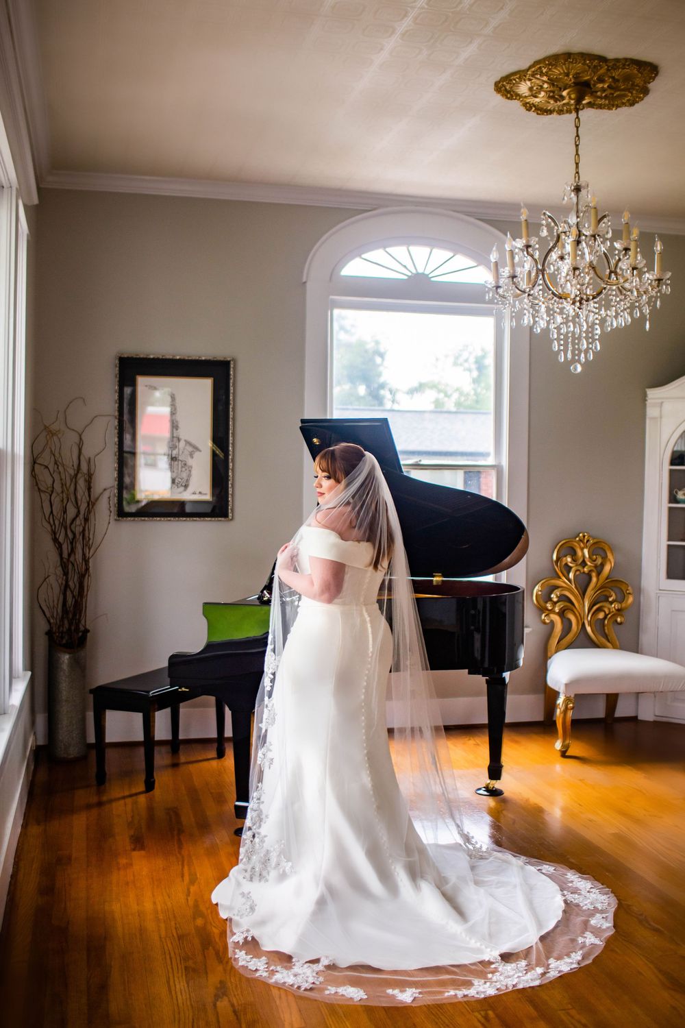 Bridal photos showing flowing veil and dress in elegant room with chandelier.