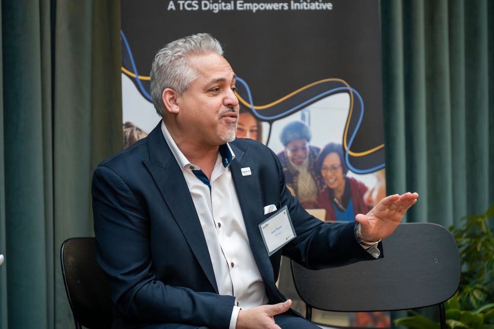 Business professionals engage in animated discussion during a corporate meeting at a conference table.