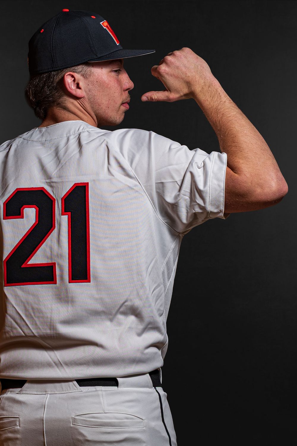 Team Media Day Photo of baseball player in jersey number 21 adjusts cap in dramatic side profile portrait - Warsaw, Indiana