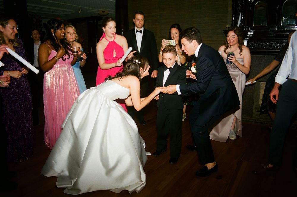 Wedding reception dance floor filled with celebrating guests in formal attire.
