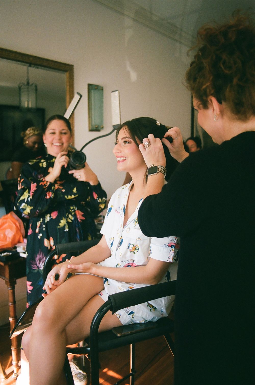 Wedding preparation scene in a bright indoor setting with formal attire. Hair and makeup getting ready morning.