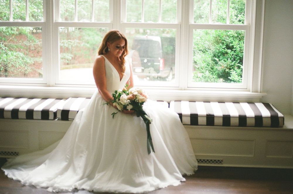 Elegant bridal portrait by window with natural light streaming in.