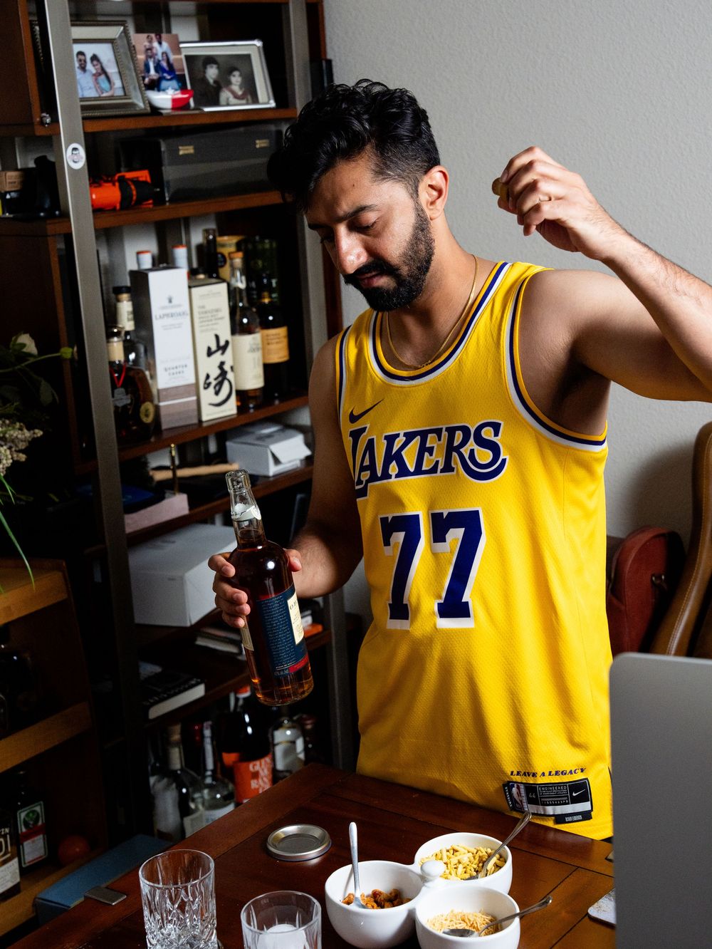 Person in Lakers jersey adding spices or ingredients to a bowl at a home kitchen counter.