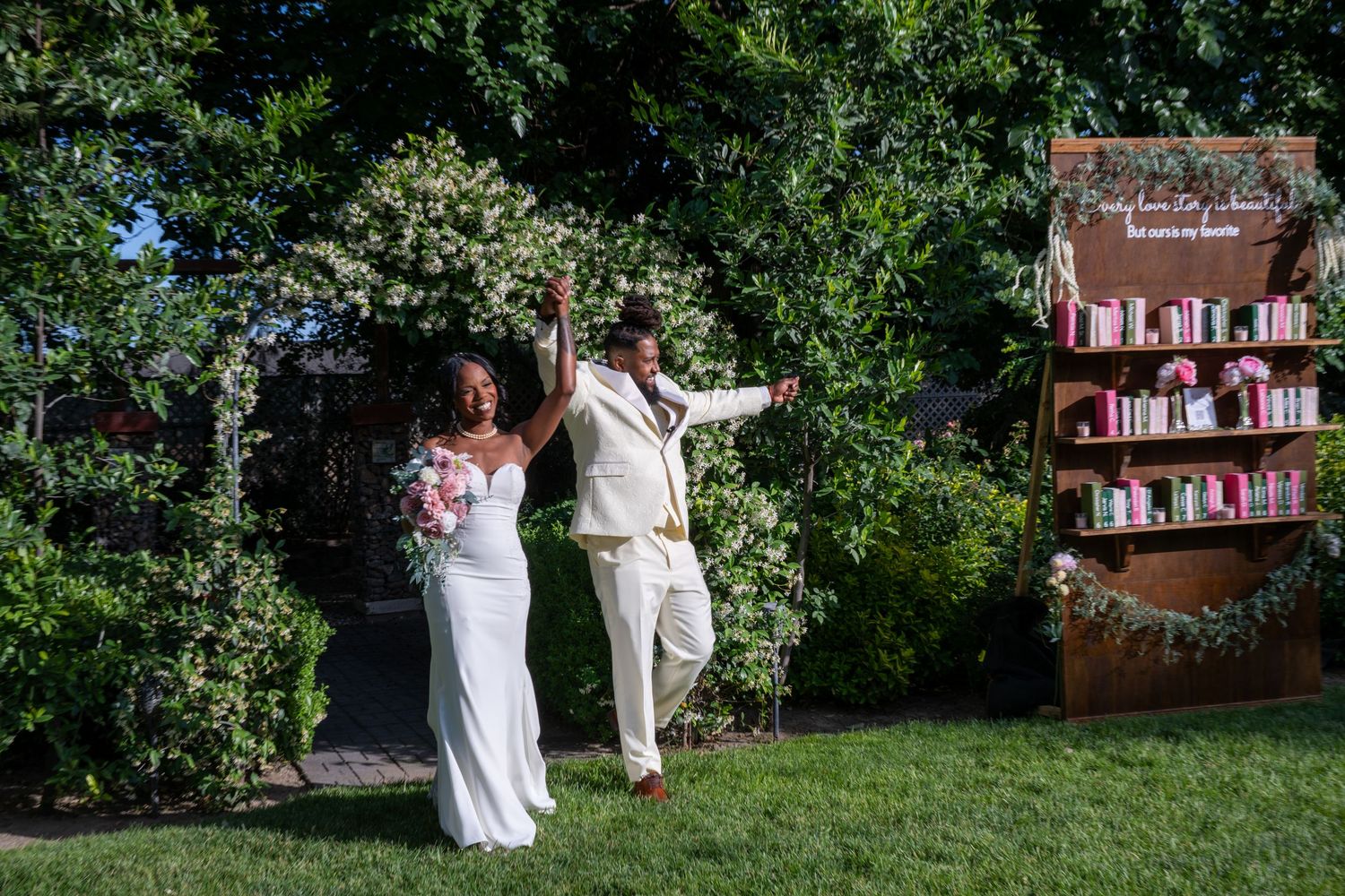 Wedding celebration in a garden with decorative bookshelf display.