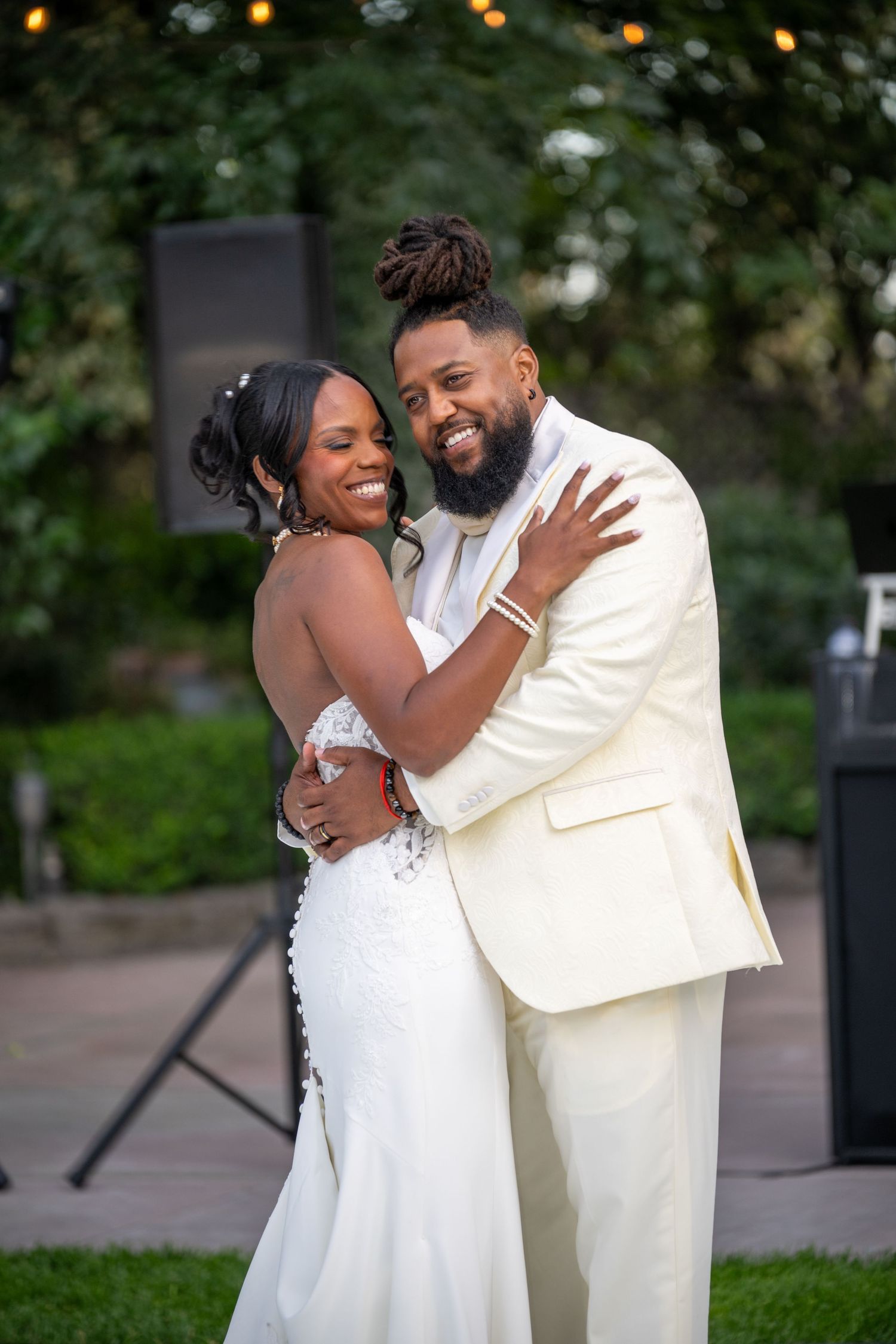 Newlyweds share a joyful embrace during their outdoor wedding celebration.