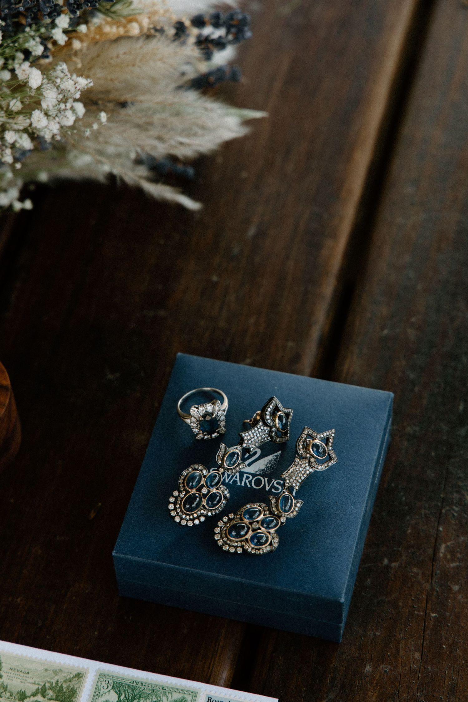 Ornate silver bridal jewelry and accessories arranged on a dark wooden surface.