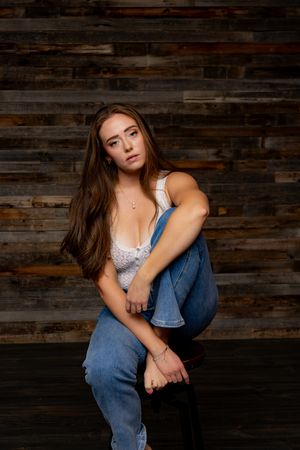 Portrait against rustic wood wall background wearing casual denim.