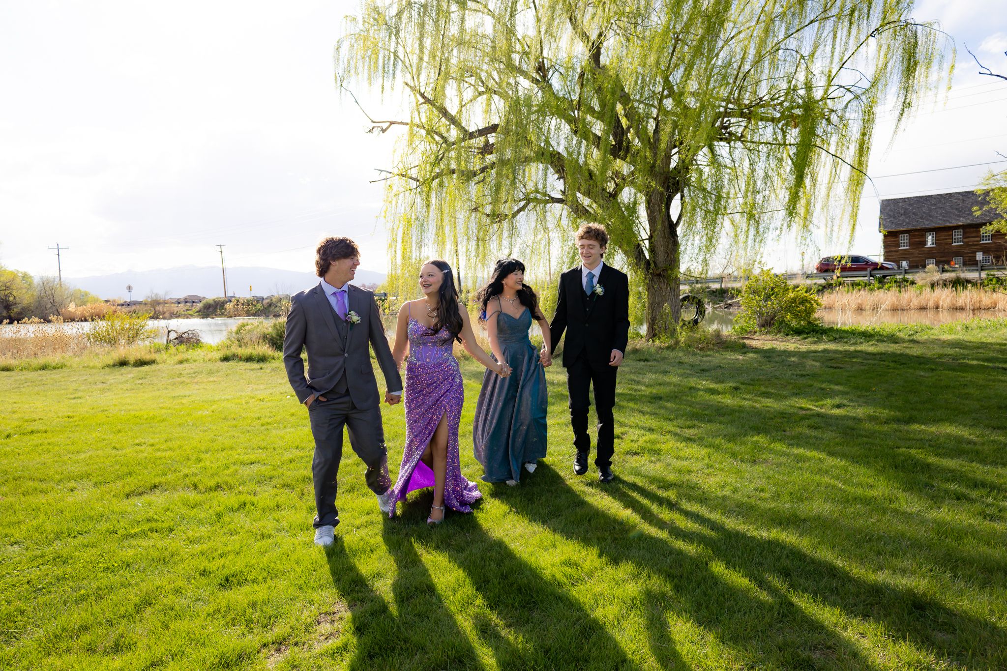 Formal group posing on grass with weeping willow tree in background.