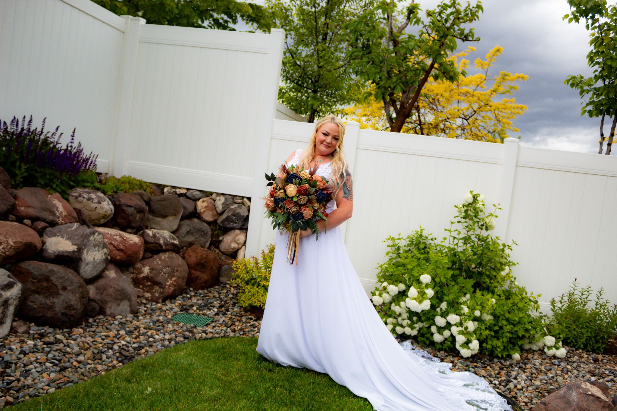 Garden wedding setup with white fabric backdrop and natural greenery.