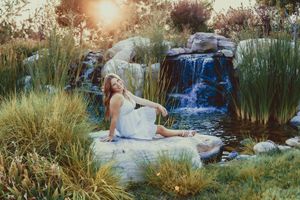 Scenic waterfall photoshoot with natural rock formations and golden sunlight.
