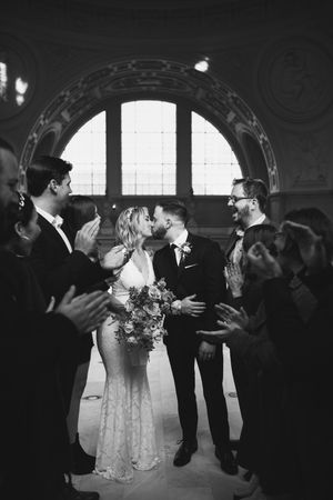 Guests clap for a newlyweds first kiss at San Francisco City Hall.