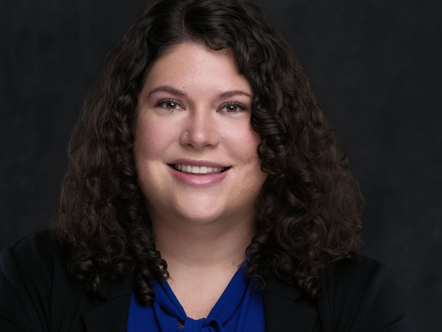 Professional headshot photography series showing different warm expressions against a dark studio background.