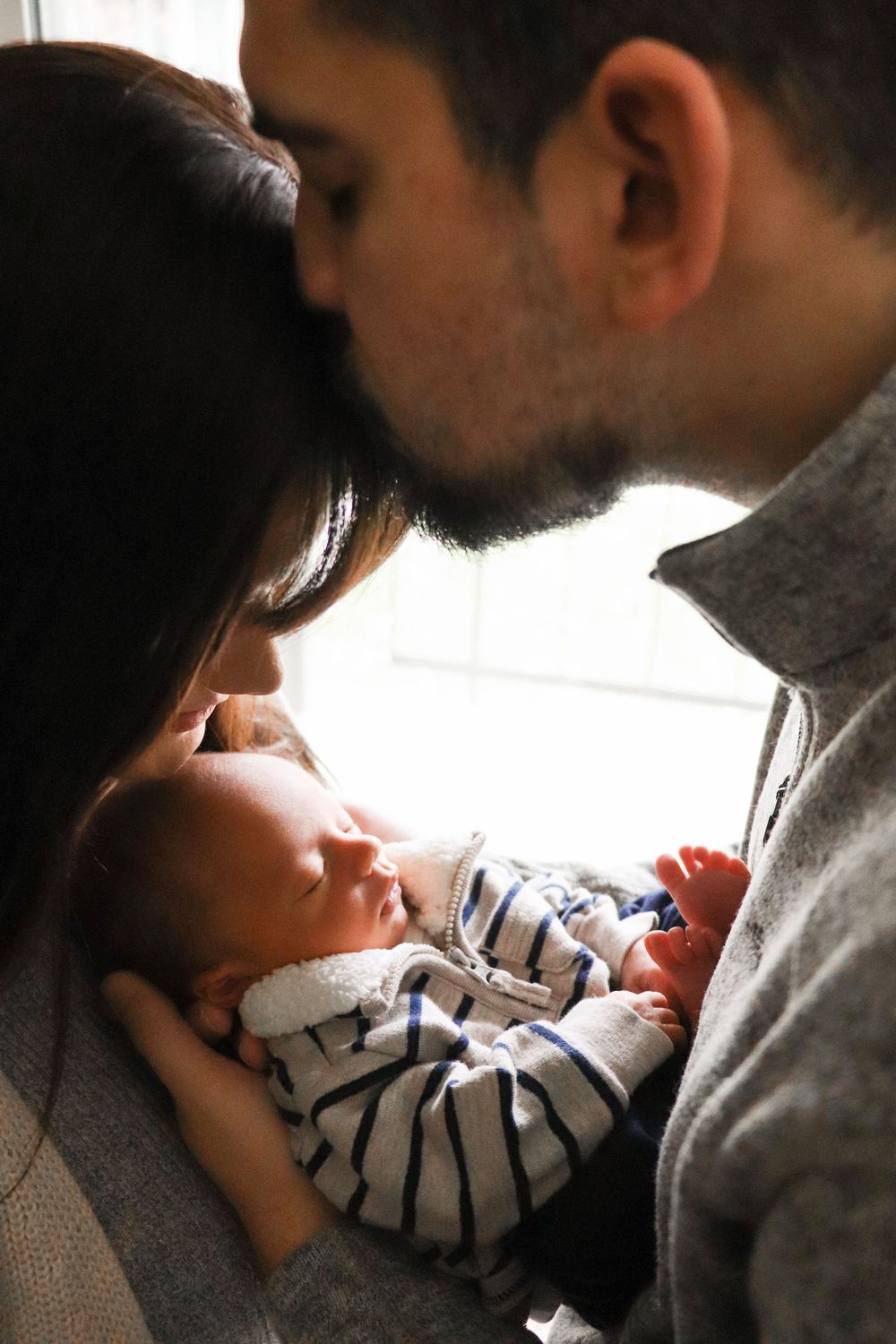 Emotional moment of dad gently kissing his newborn during in-home session in Tri-Cities WA